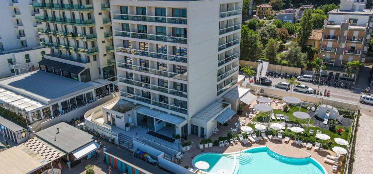 Hotel moderno con piscina, vicino alla spiaggia, atmosfera estiva e rilassante.