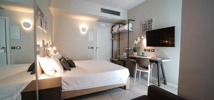 Camera moderna e accogliente con letto, scrivania e TV.